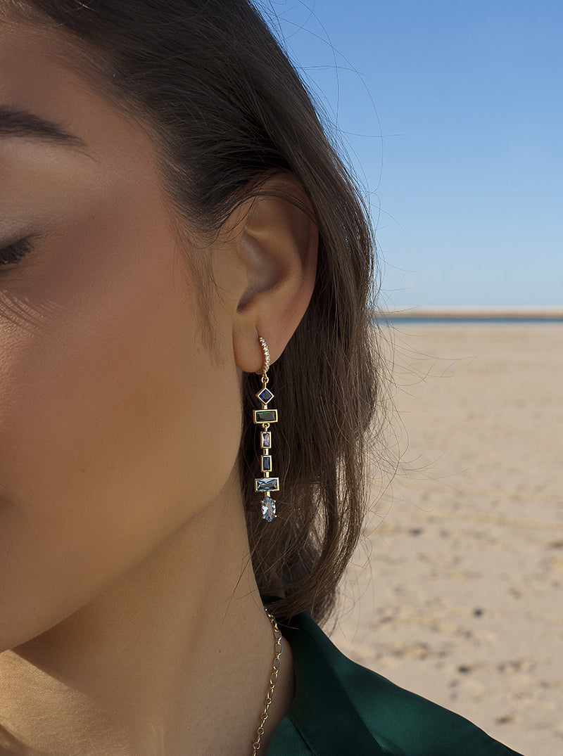 Boucles d'oreilles longues ornées de pierres de formes variées dans des tons froids