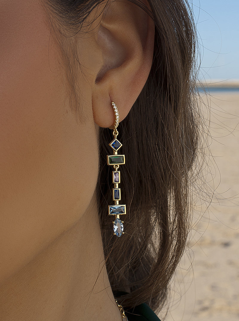 Boucles d'oreilles longues ornées de pierres de formes variées dans des tons froids