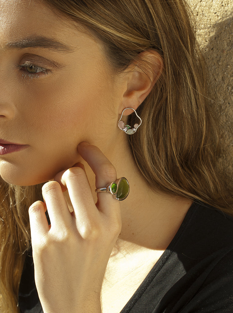 silver ring with green stones in a modern design