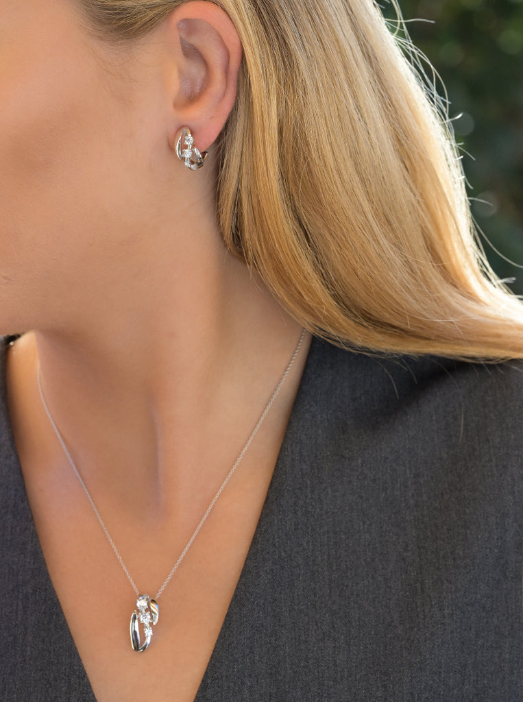Omega clasp earrings with three cubic zirconia and curved design
