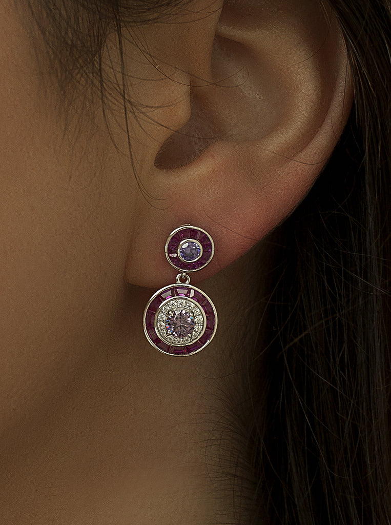 Earrings with circular colored stones in a fuchsia tone