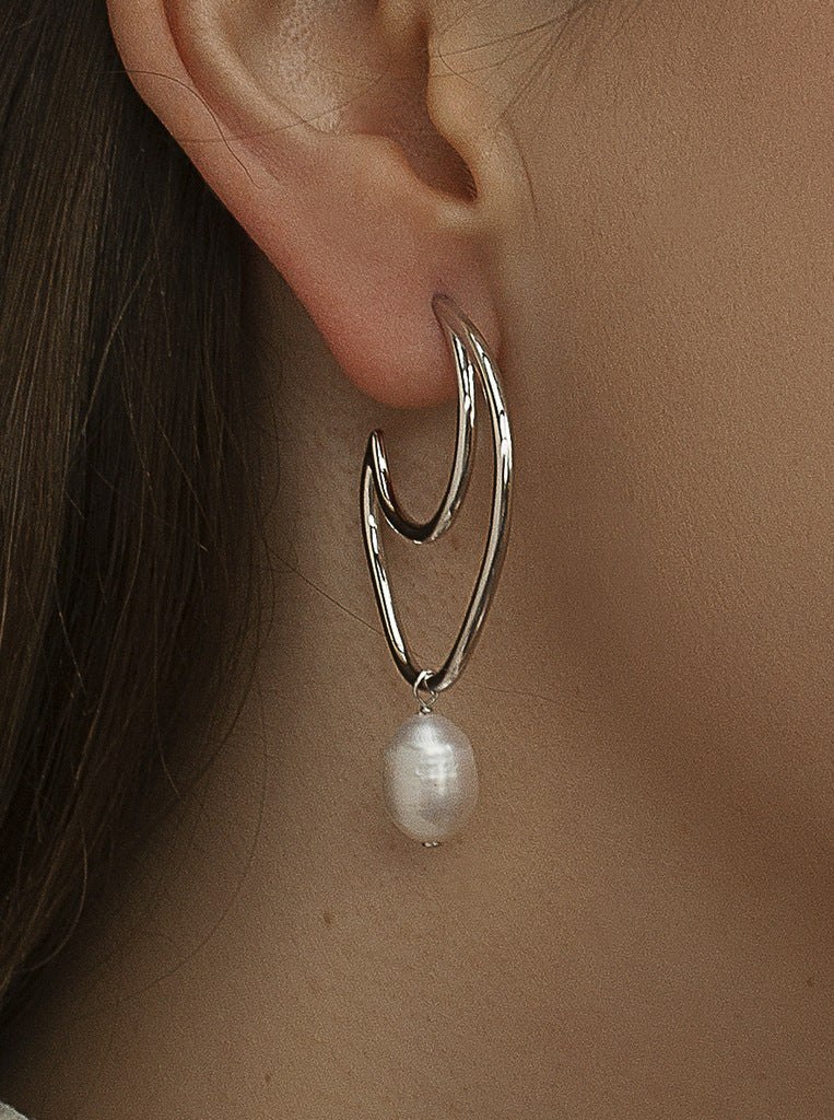 Boucles d'oreilles minimalistes originales avec une perle pendante.