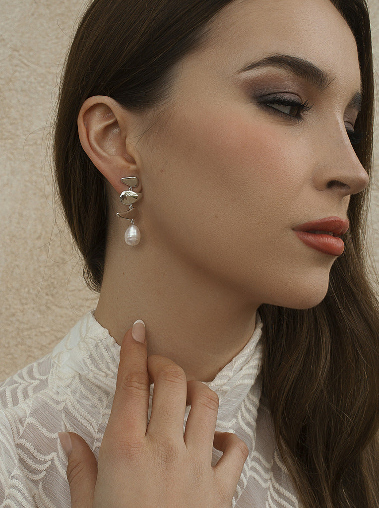 Silver pearl earrings with an organic and fluid structure