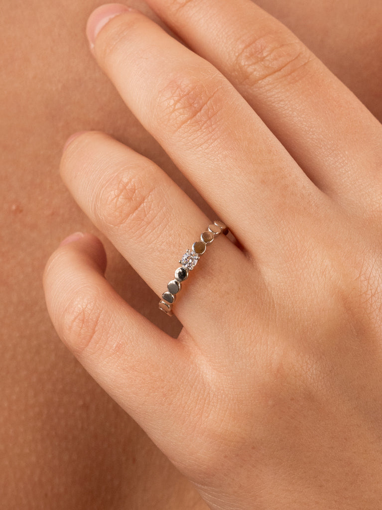 Anillo fino de plata con piezas circulares y circonita central