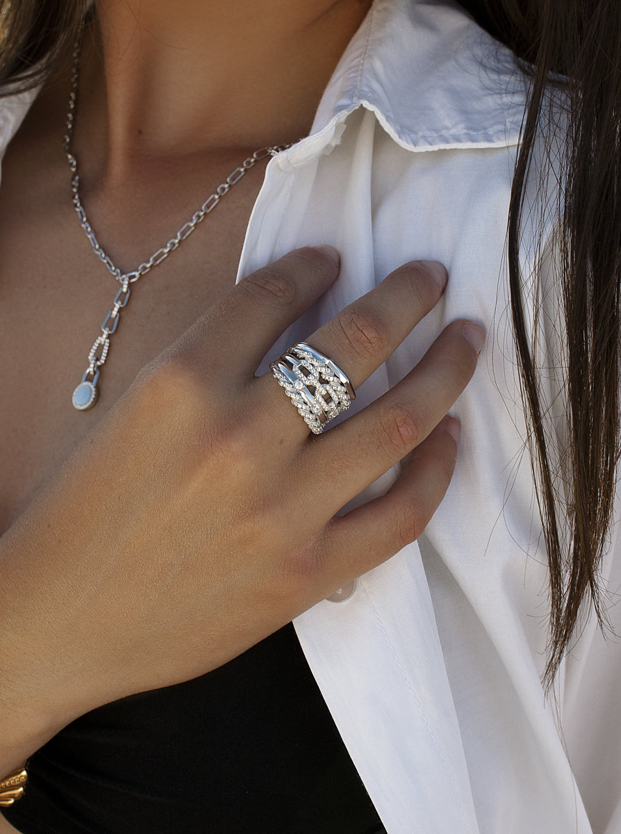 Anillo ancho de plata con circonitas y diseño entrelazado