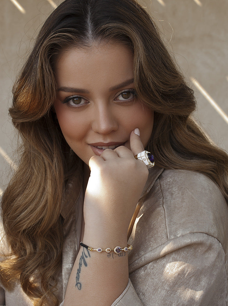 Anillo de plata bañada en oro con esmalte blanco piedra morada y circonitas
