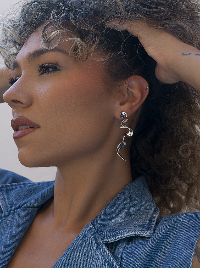 Pendientes largos plateados de diseño ondulado y escultural