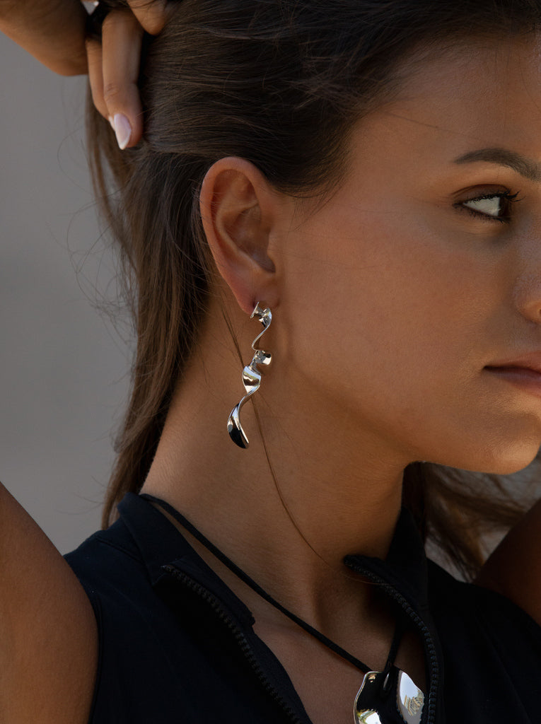 Pendientes largos plateados de diseño ondulado y escultural