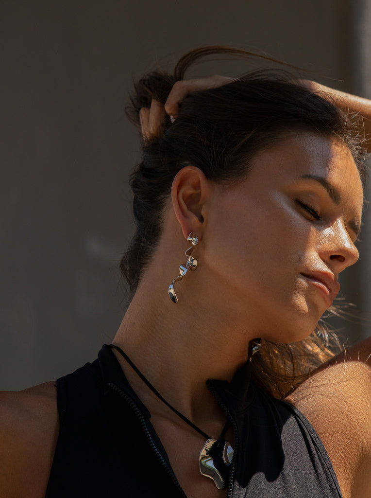 Pendientes largos plateados de diseño ondulado y escultural