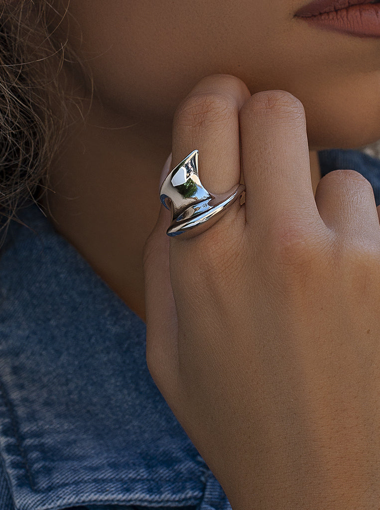 Anillo plateado escultural de diseño orgánico y fluido
