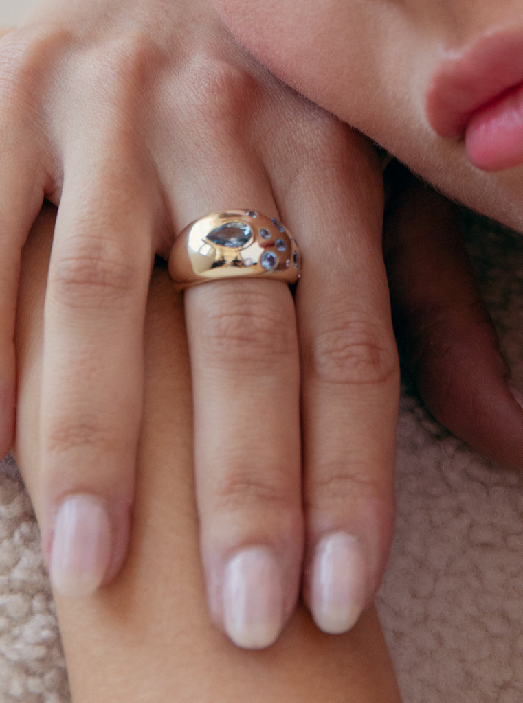 Anillo abombado de plata bañada en oro con piedras azules