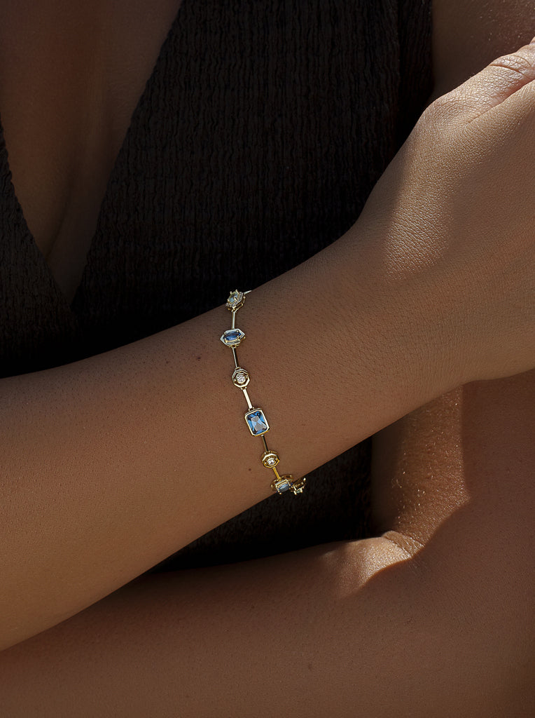 Pulsera fina de plata bañada en oro con piedras azules y brillo
