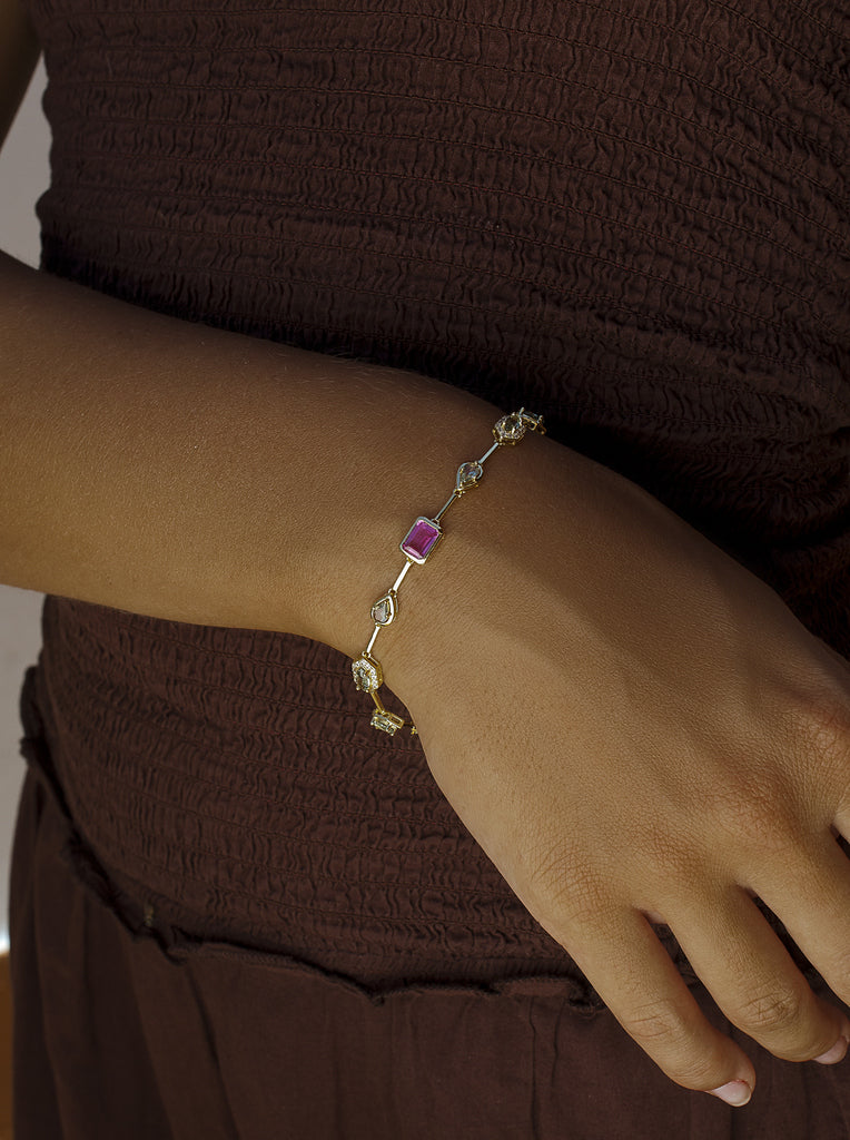 Pulsera de plata dorada con piedra fucsia central y circonitas
