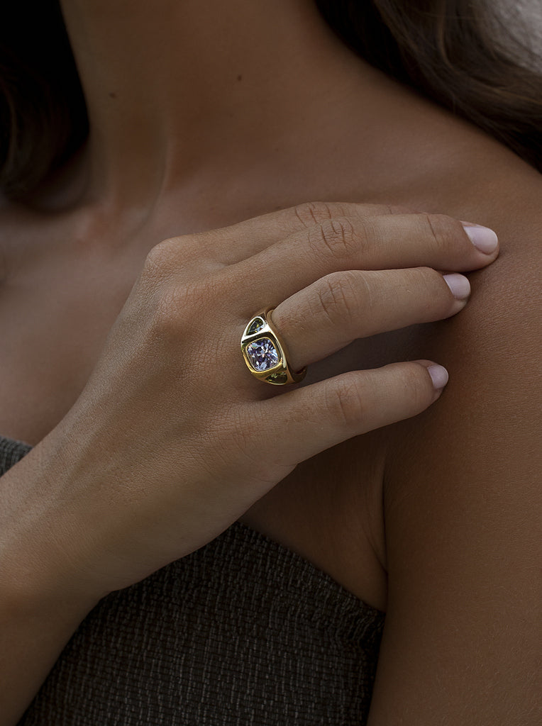Anillo sello de plata bañado en oro con piedra lila central y laterales verdes