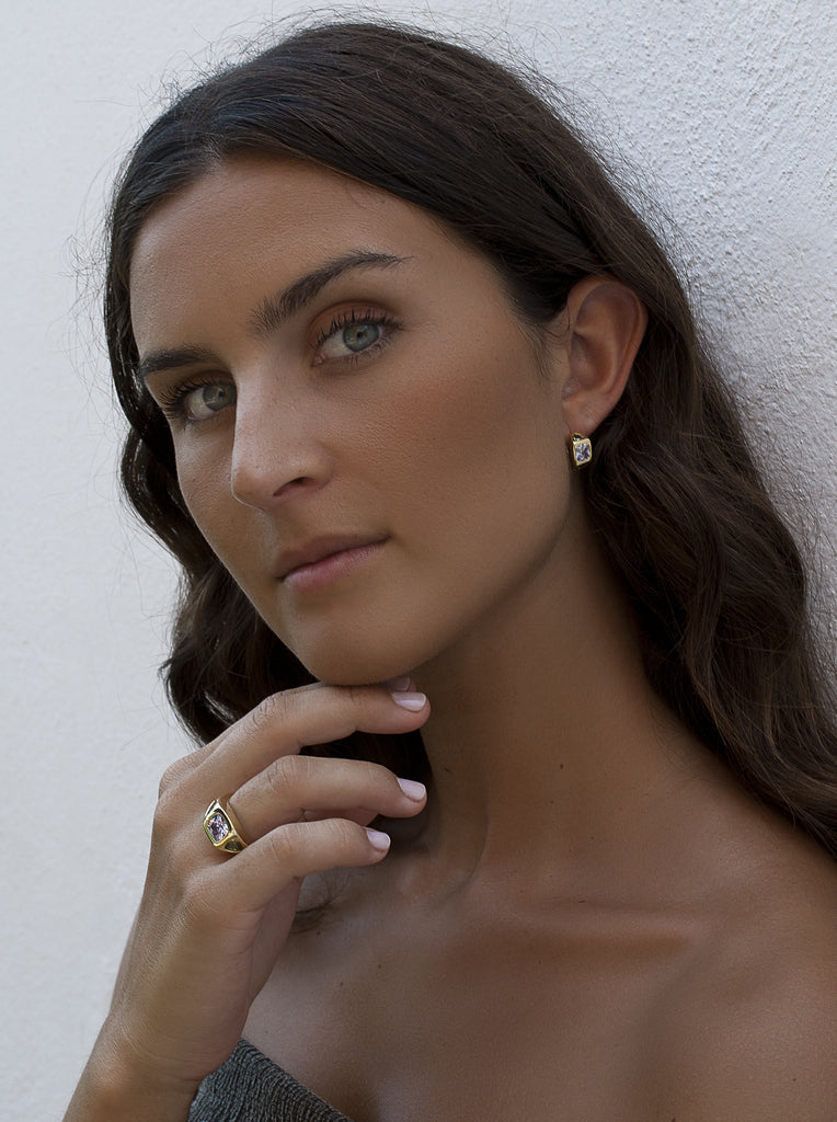 Anillo sello de plata bañado en oro con piedra lila central y laterales verdes