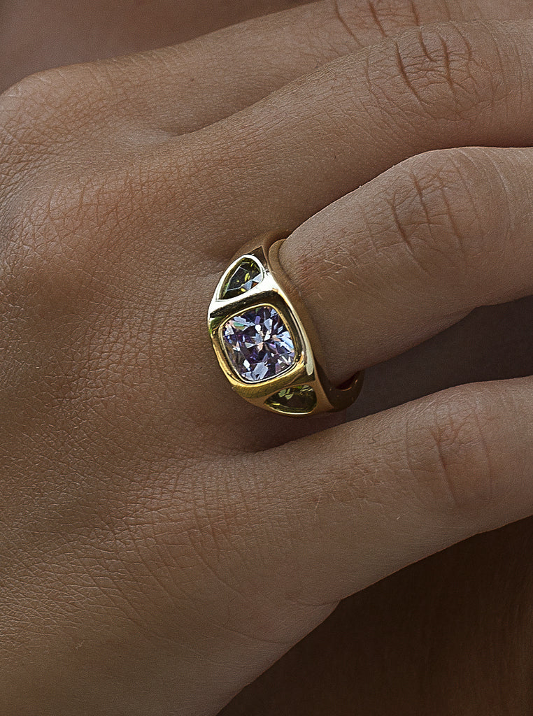 Anillo sello de plata bañado en oro con piedra lila central y laterales verdes