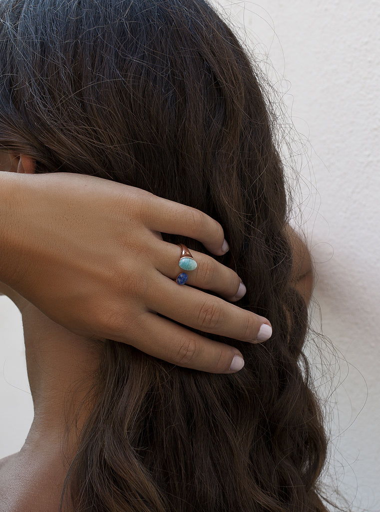 Anillo abierto de plata tono oro rosa con piedras azules