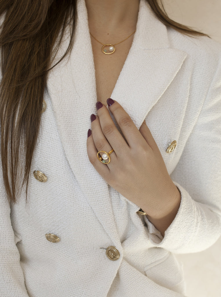 Anillo dorado con perla y piedra verde diseño círculo