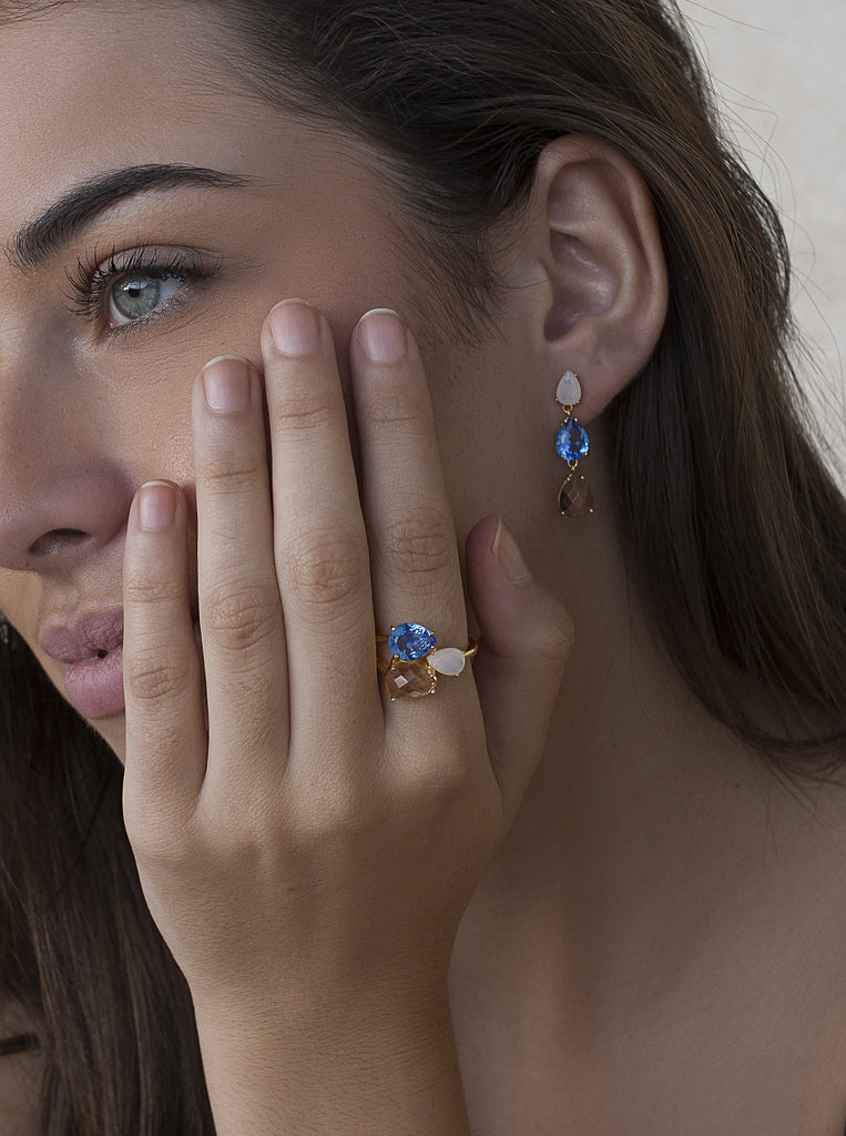 Anillo de plata acabado dorado con triple piedra azul blanco y champagne