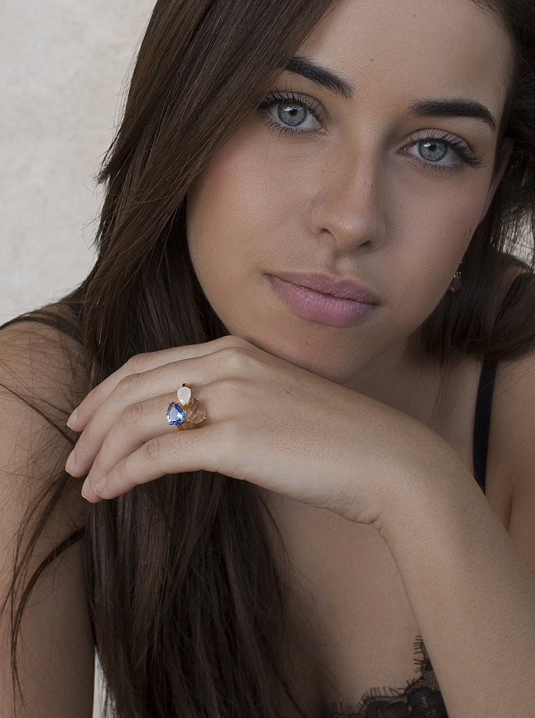 Anillo de plata acabado dorado con triple piedra azul blanco y champagne