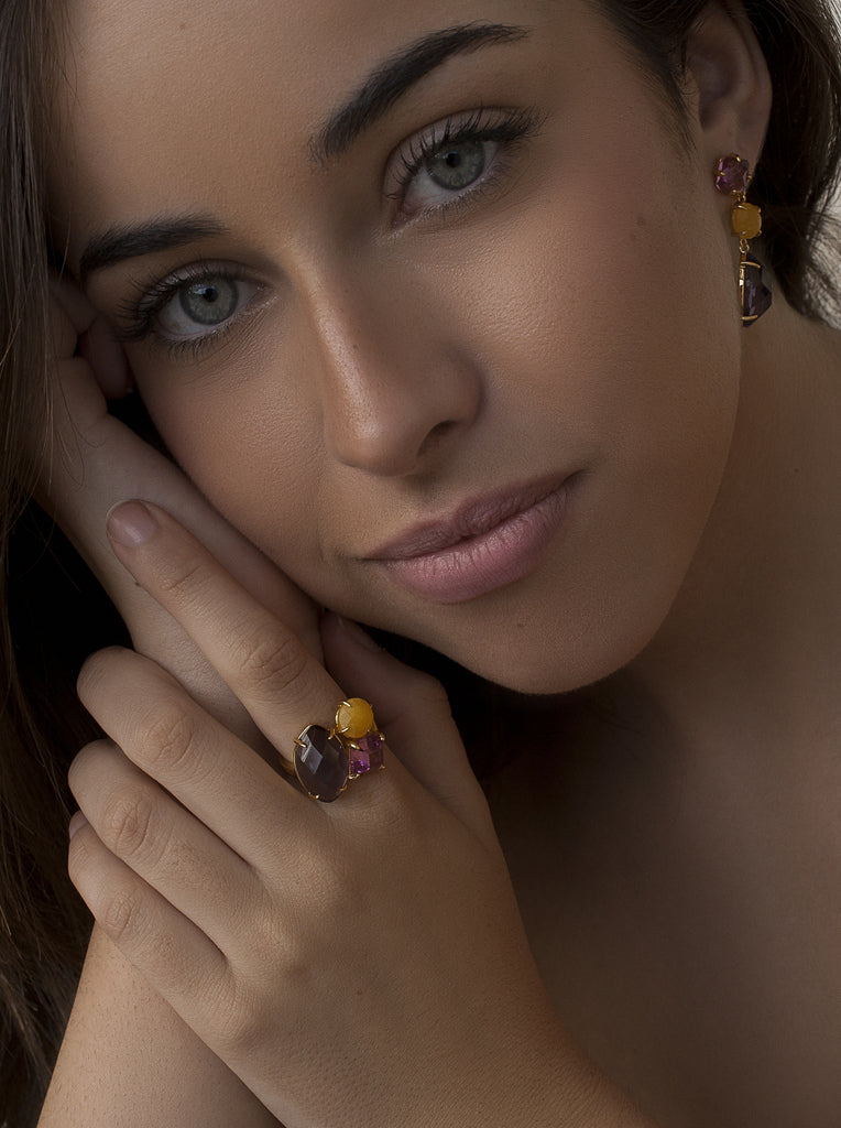 Anillo de plata dorada con piedras violetas y amarilla