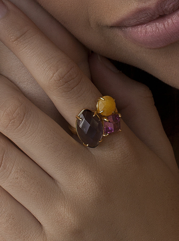 Anillo de plata dorada con piedras violetas y amarilla
