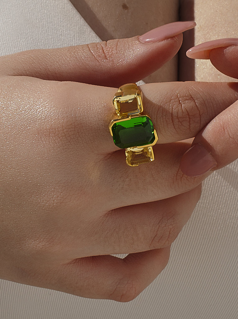 Anillo de plata bañado en oro con piedras verde esmeralda y champagne