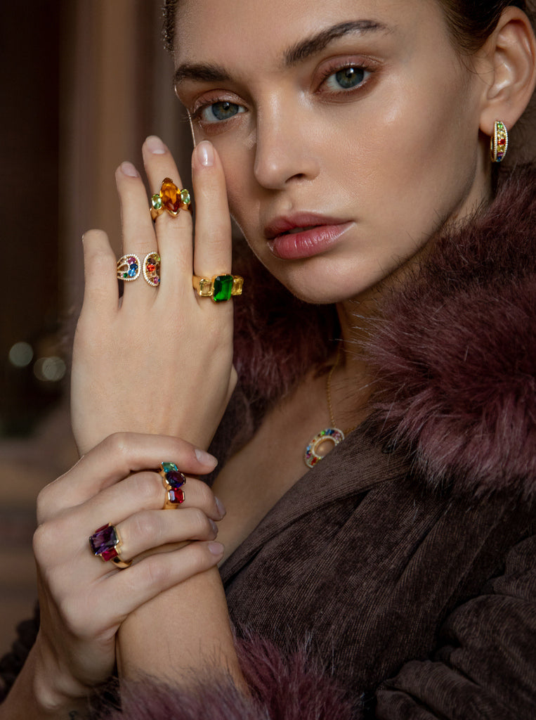 Anillo de plata bañado en oro con piedra naranja ámbar y detalles verdes