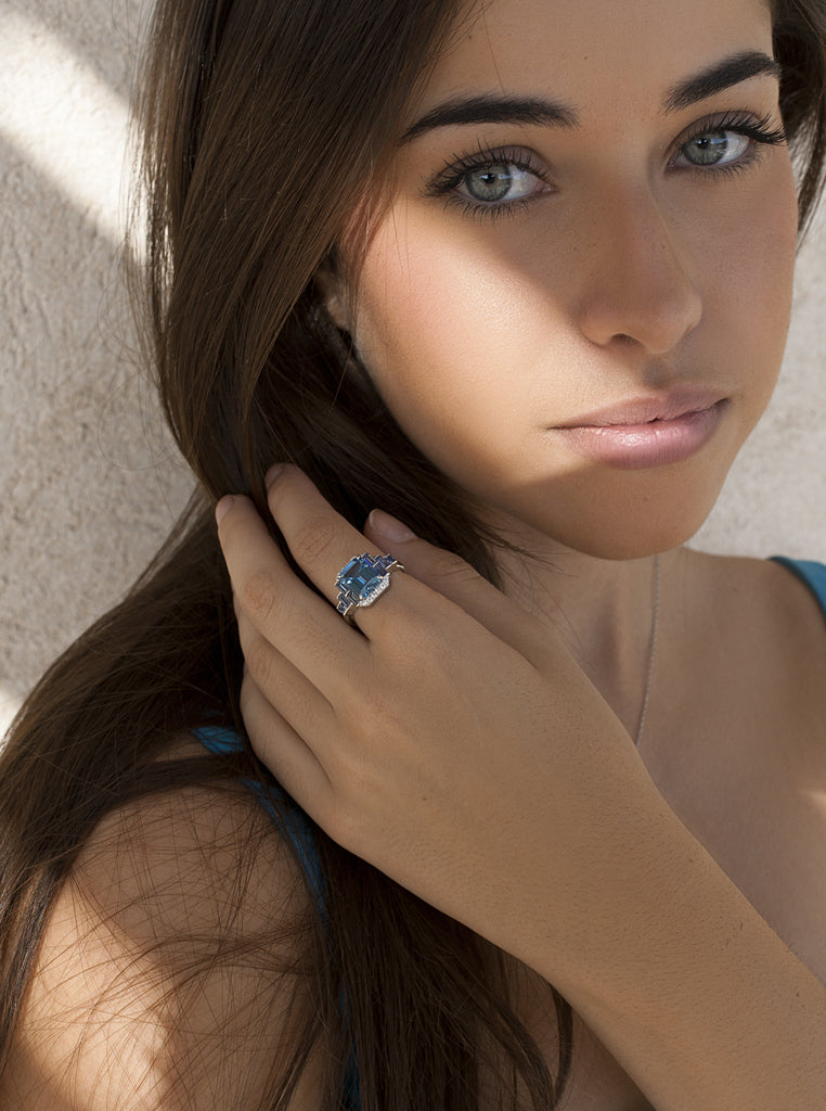 Anillo de plata con piedra azul rectangular y detalles lila