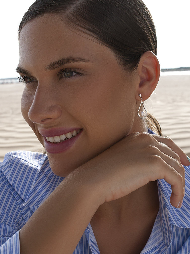 Long silver earrings with a pearl in a teardrop frame