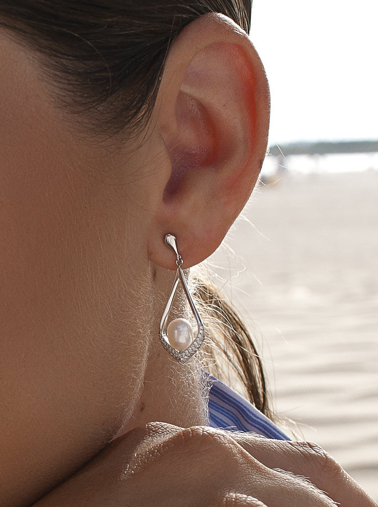 Long silver earrings with a pearl in a teardrop frame