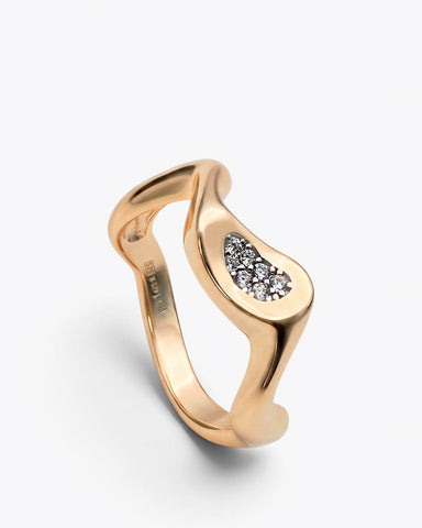 Anillo dorado de diseño ondulado con piedras blancas
