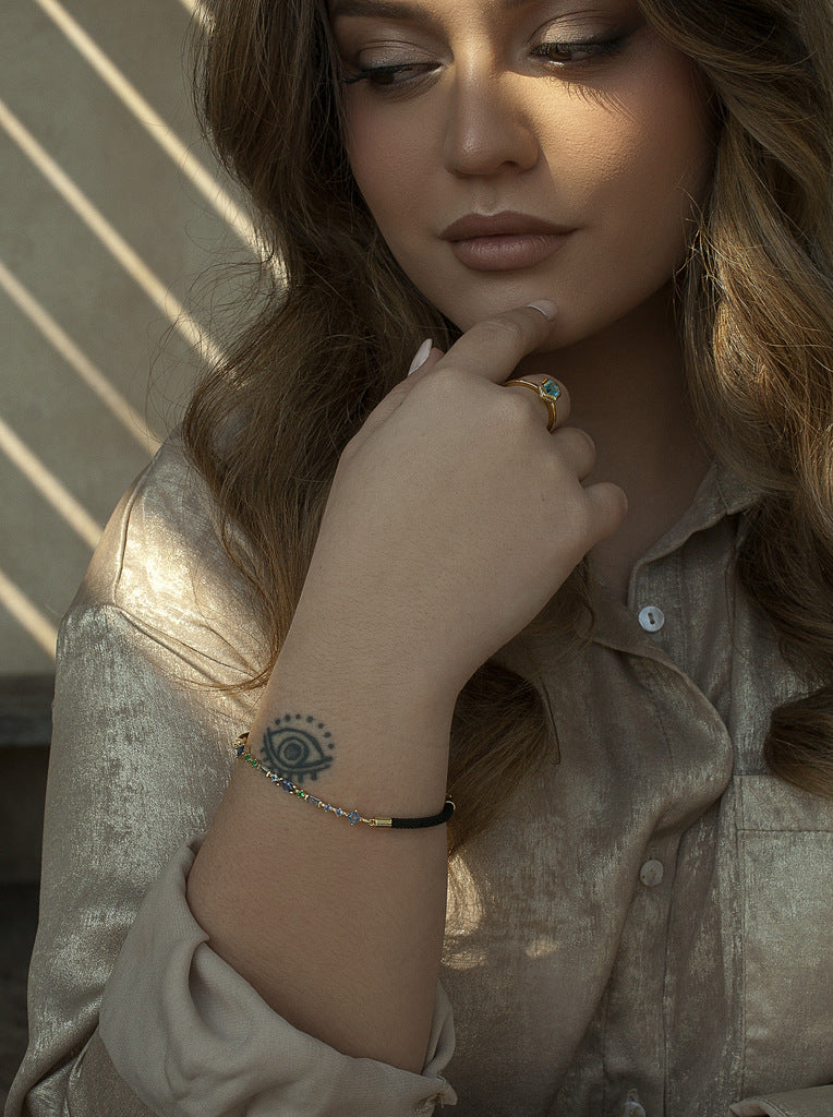 Pulsera de plata con piedras azules y cordón negro