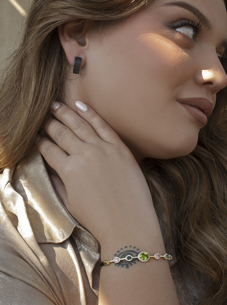 Pulsera de plata con piedras de colores en tonos verdes y cordón negro