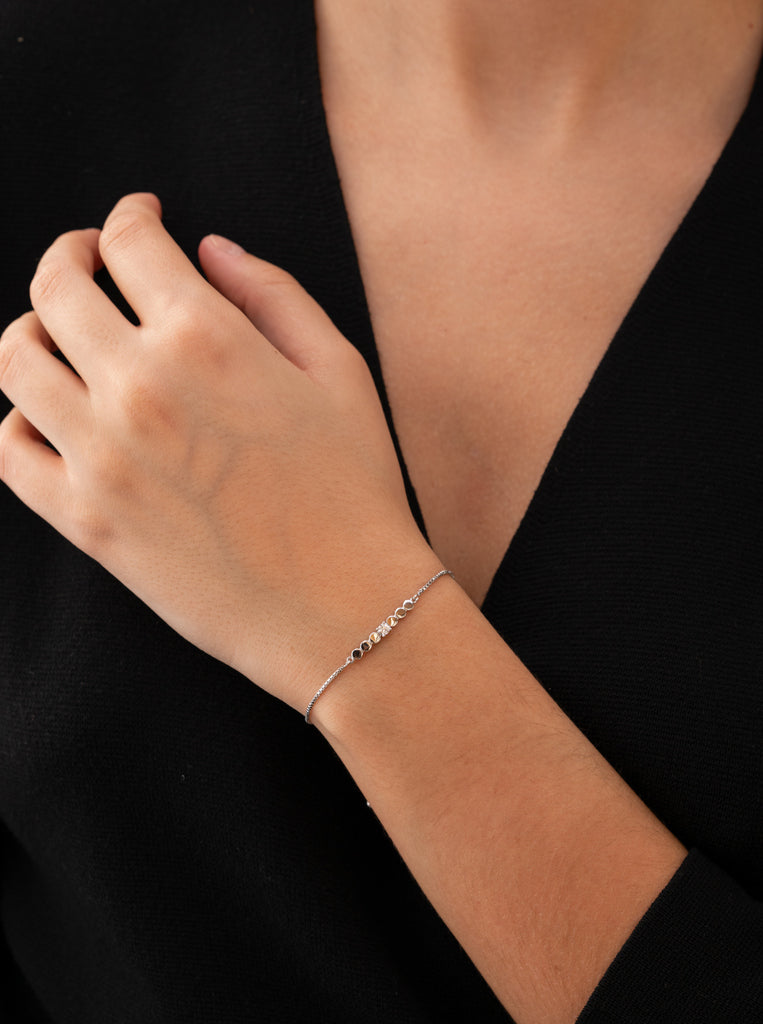 Pulsera fina de plata con piezas circulares y circonita central
