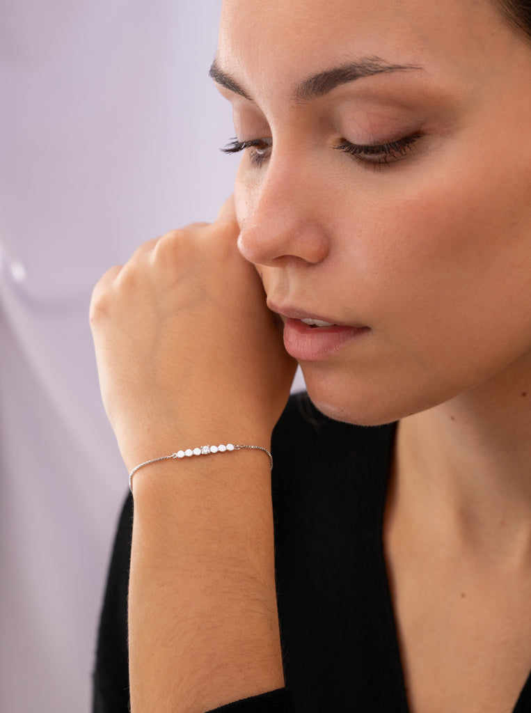 Pulsera fina de plata con piezas circulares y circonita central