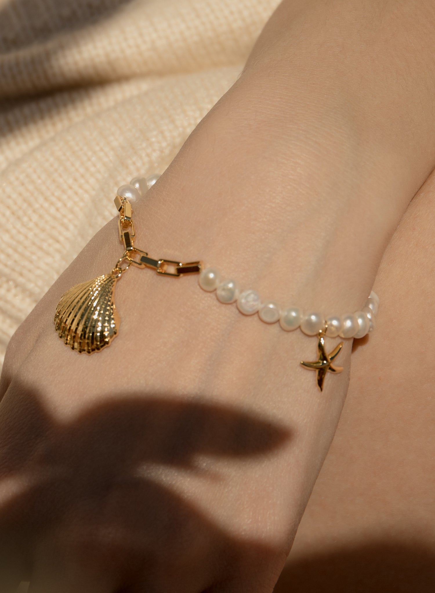Pulseras de perlas en oro diseño charms de concha y estrella de mar-LINEARGENT
