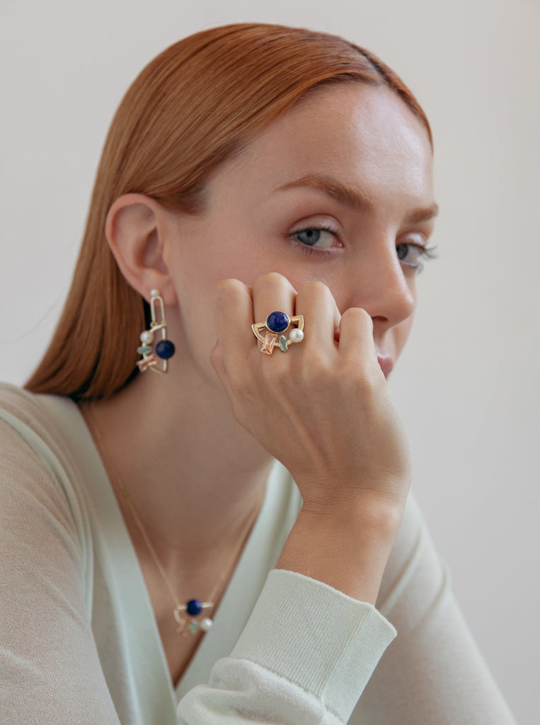 anillo dorado con piedras multicolores y perla