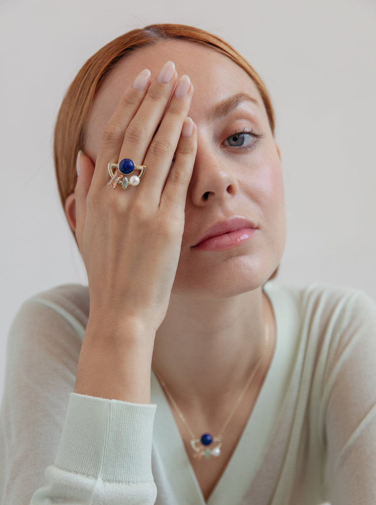 anillo dorado con piedras multicolores y perla