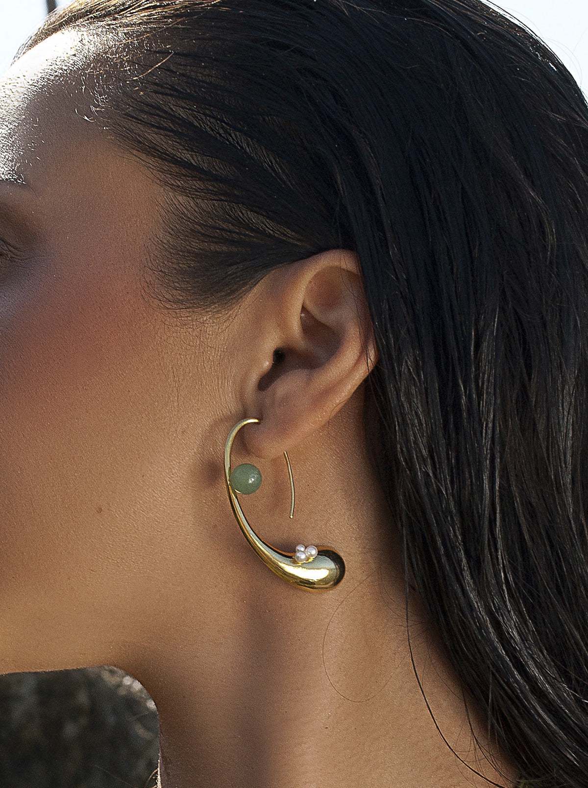 Pendientes curvos dorados con perlas y piedra verde
