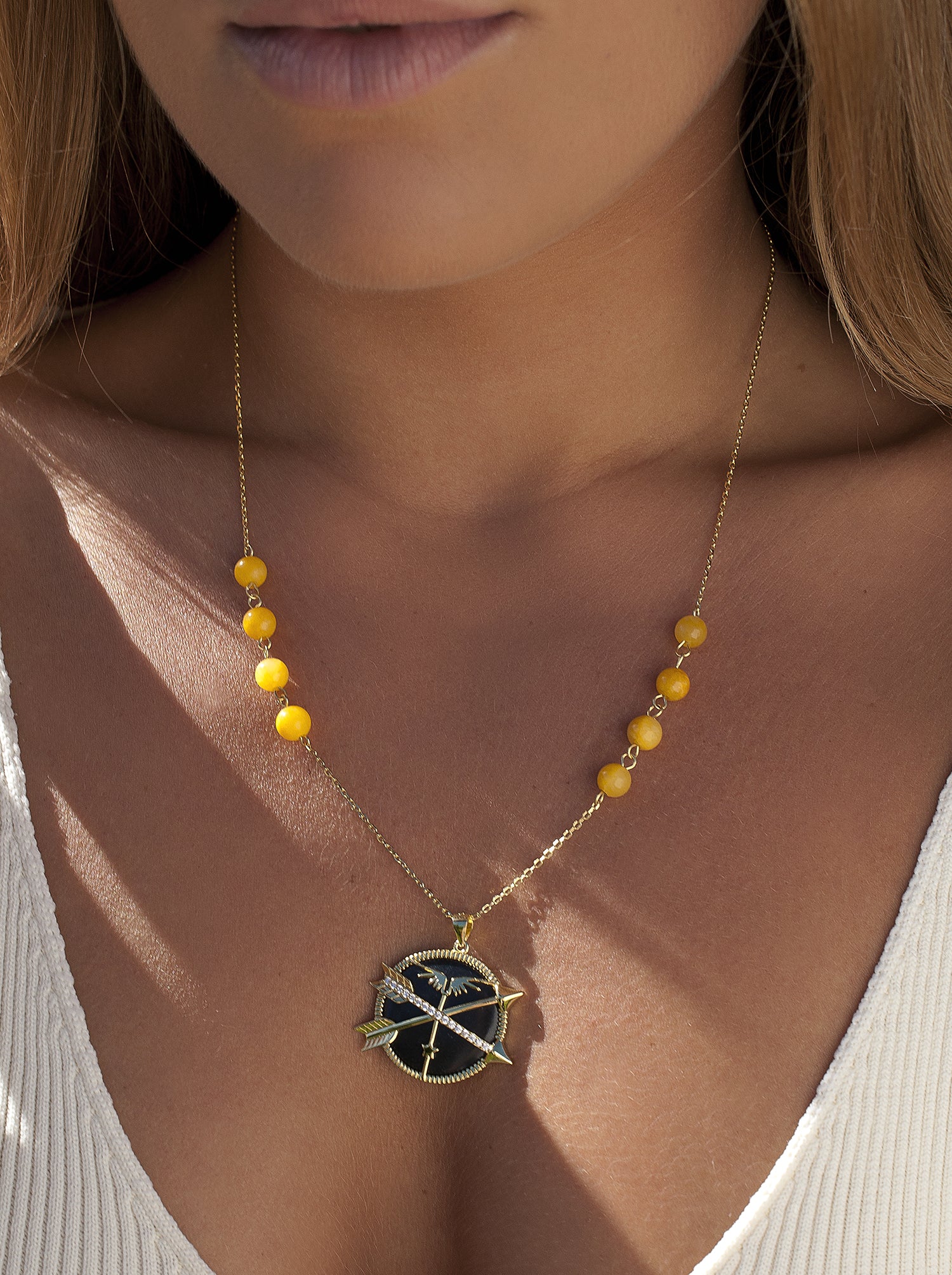 collier médaille motif central formé par deux flèches et zircons