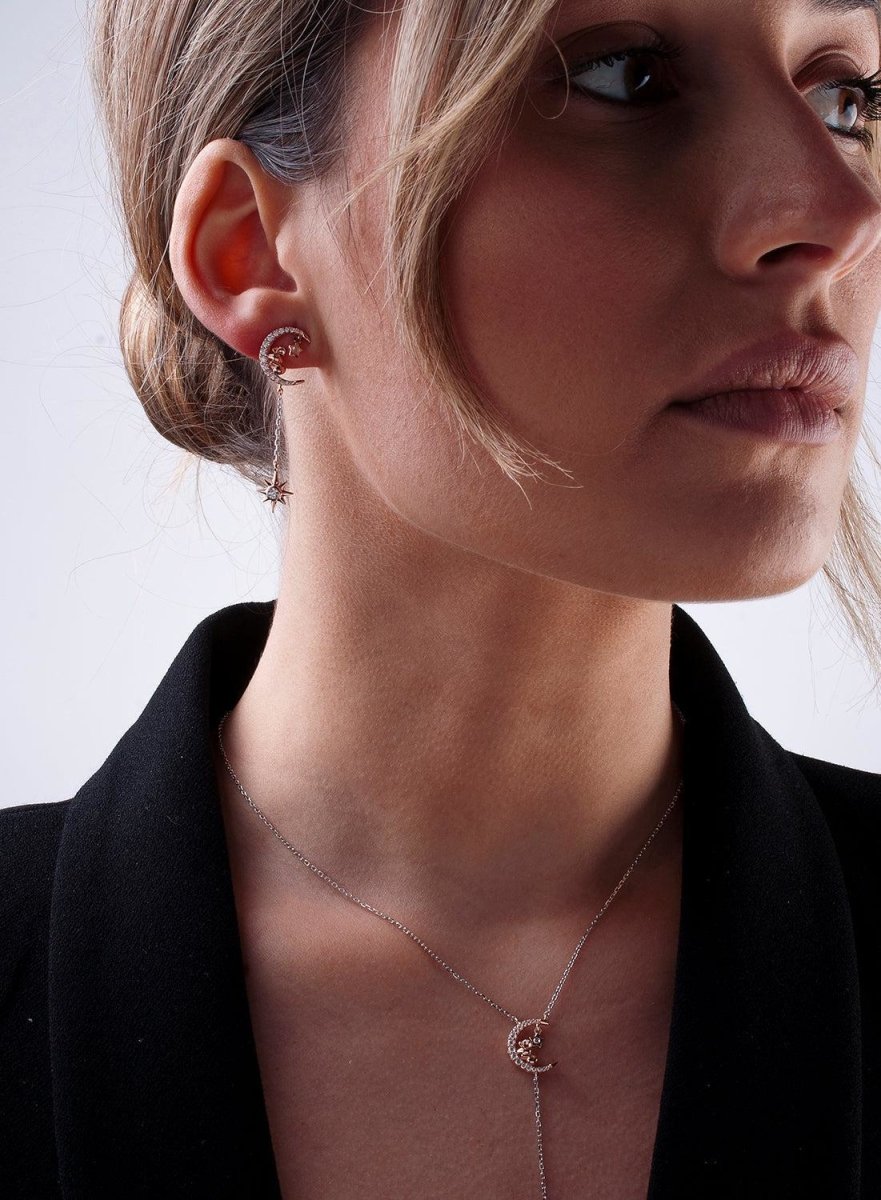 Pendientes largos brillantes compuestos por motivos de luna y estrella